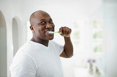 man-smiling-as-he-brushes-his-teeth.jpeg
